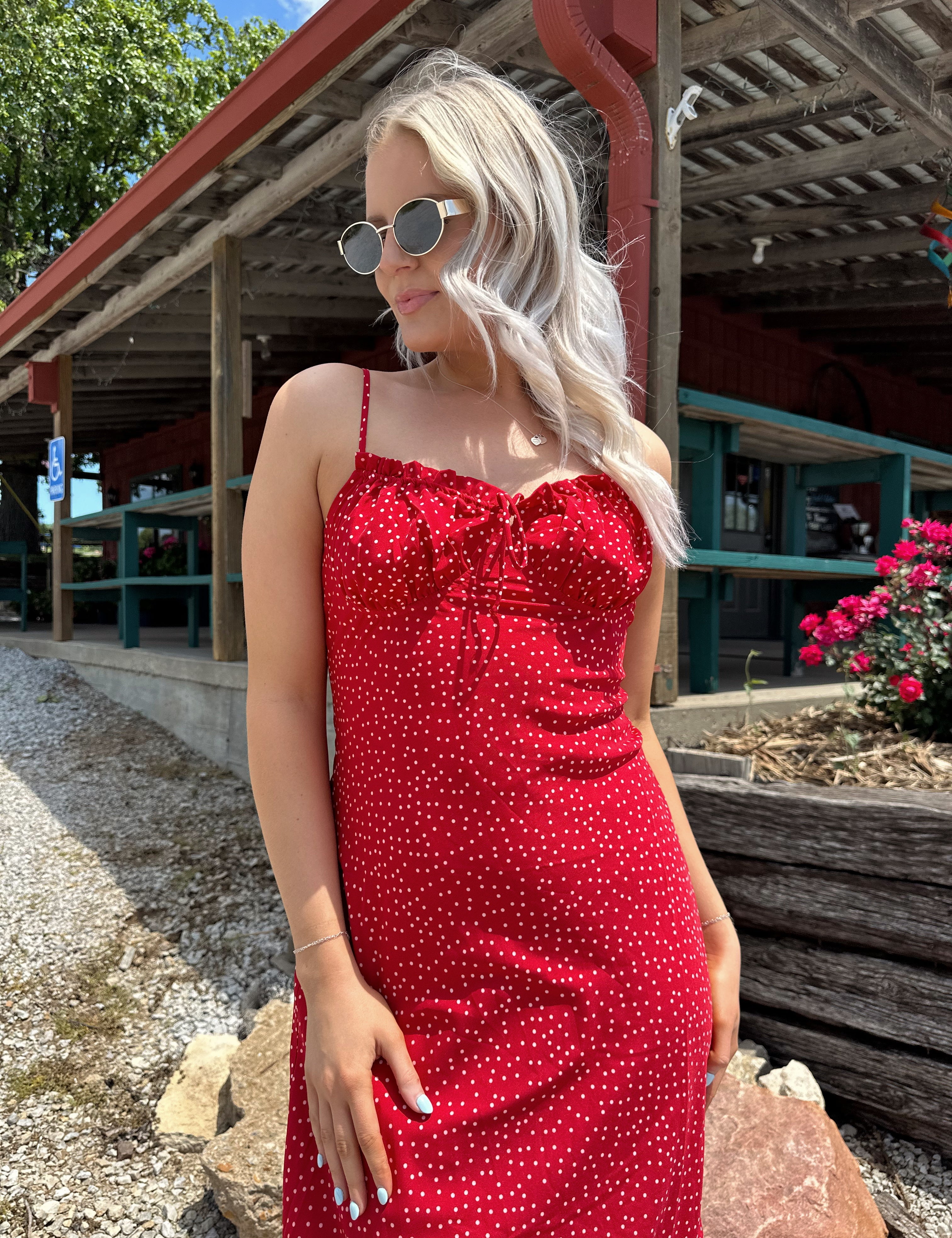 Red and white polka dot midi dress with adjustable spaghetti straps and tie neckline.