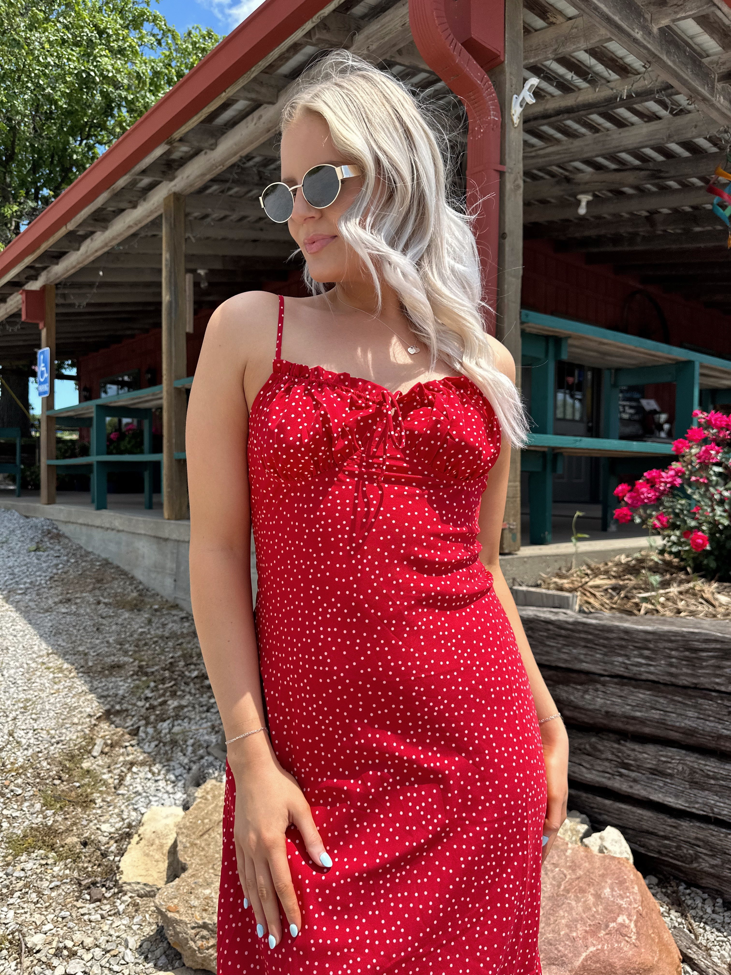 Red and white polka dot midi dress with adjustable spaghetti straps and tie neckline.