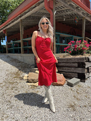 Red and white polka dot midi dress with adjustable spaghetti straps and tie neckline.