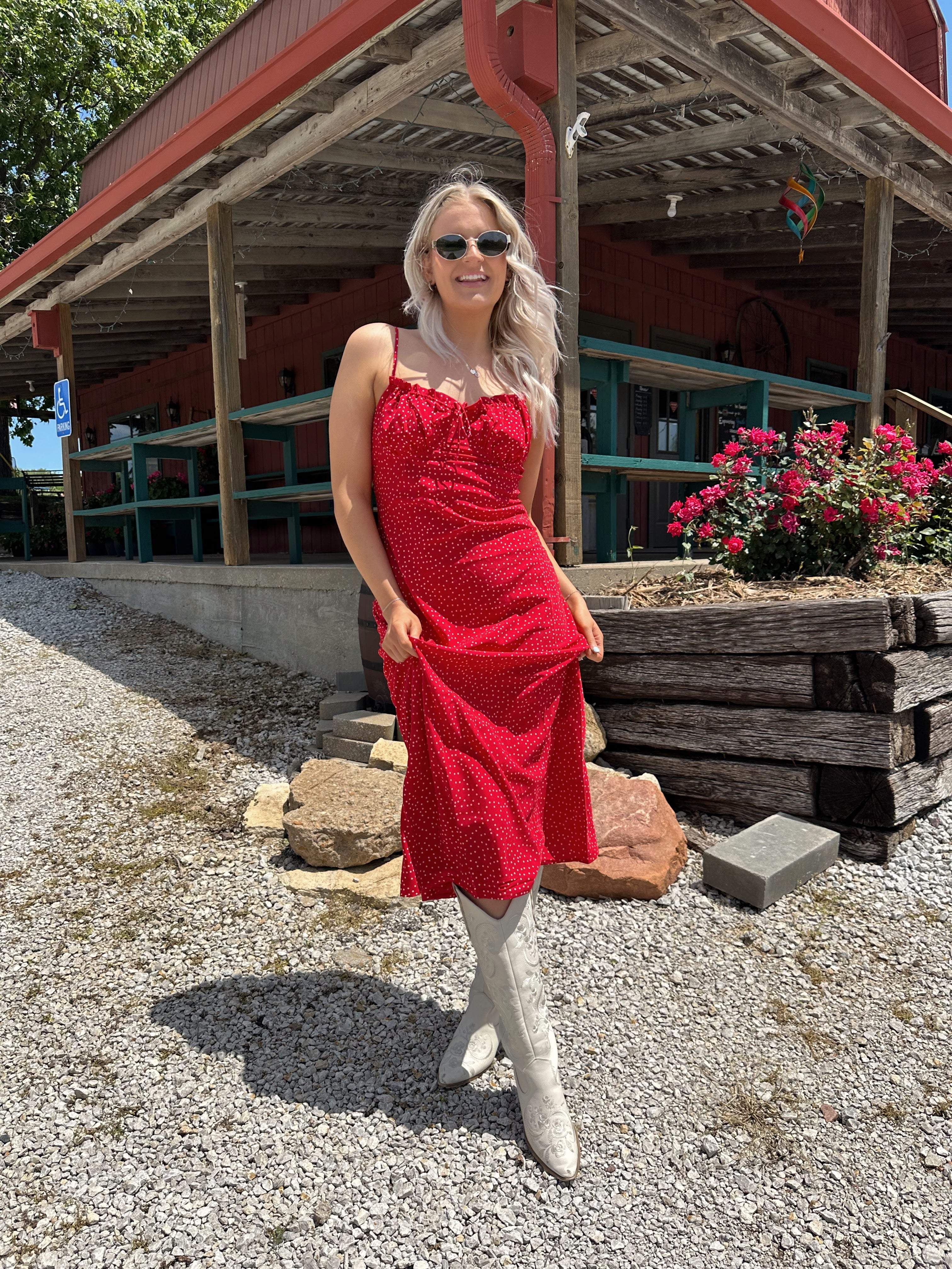 Red and white polka dot midi dress with adjustable spaghetti straps and tie neckline.