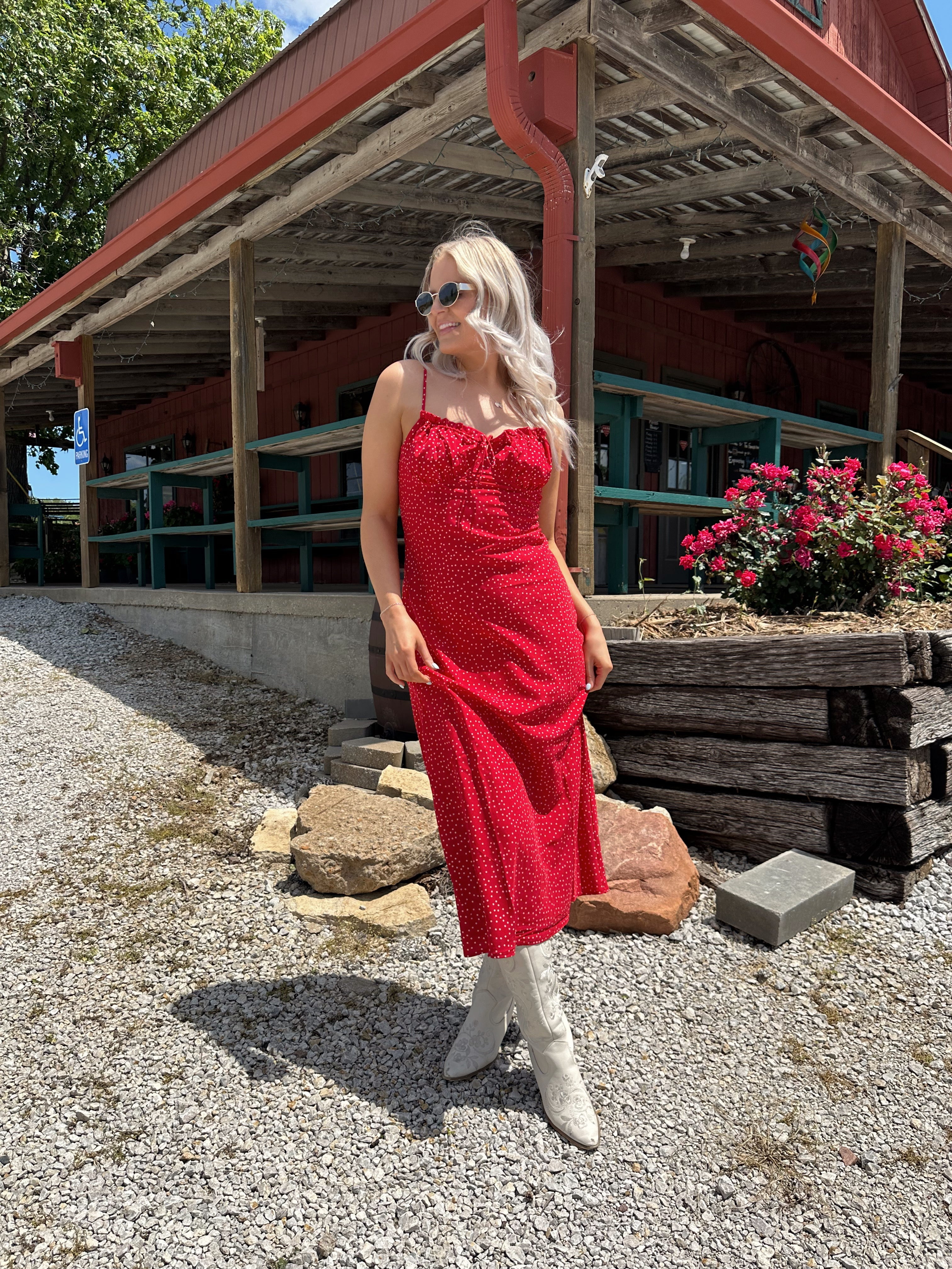 Red and white polka dot midi dress with adjustable spaghetti straps and tie neckline.