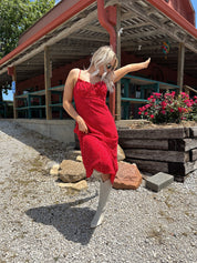 Red and white polka dot midi dress with adjustable spaghetti straps and tie neckline.