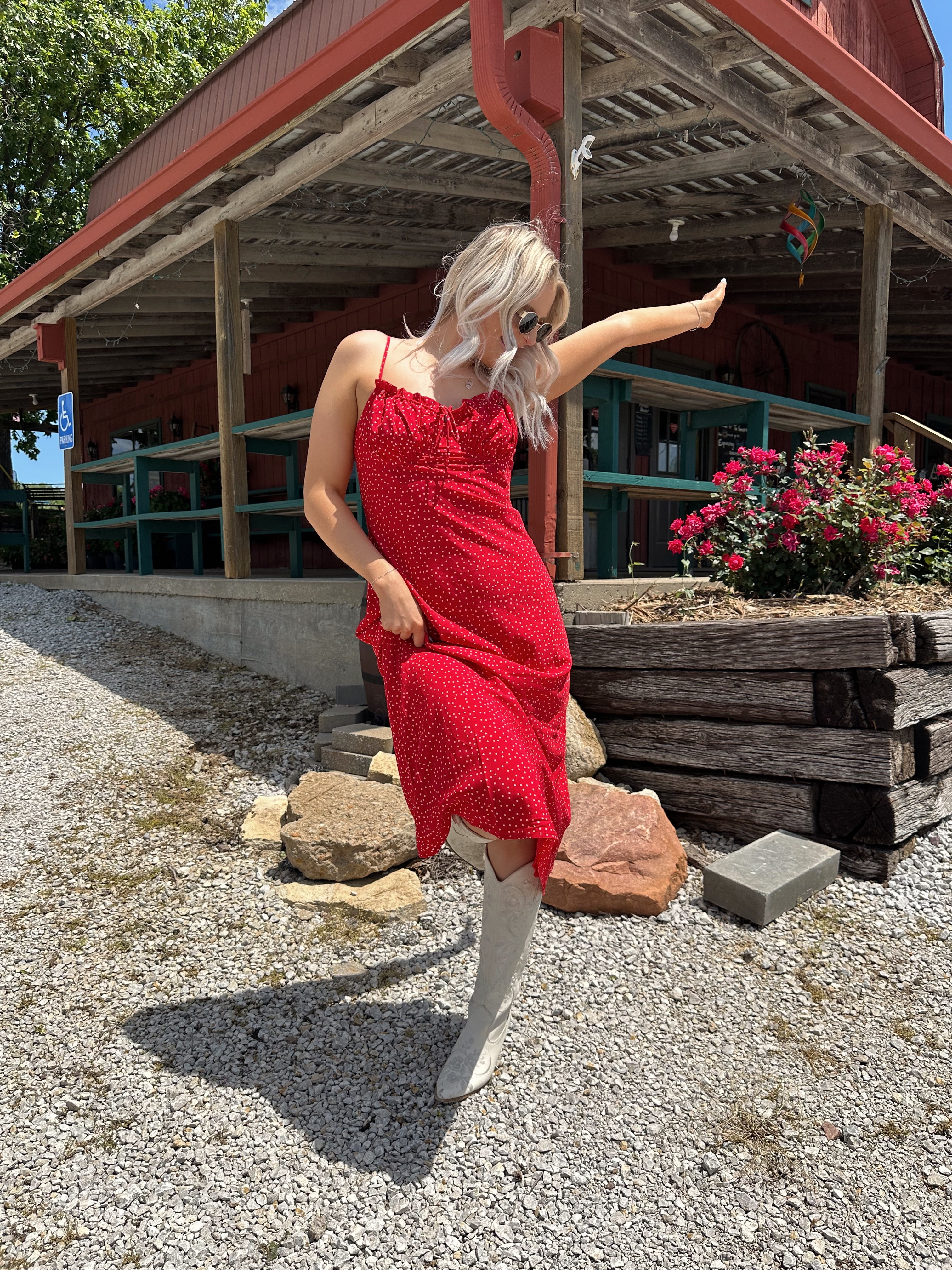 Red and white polka dot midi dress with adjustable spaghetti straps and tie neckline.