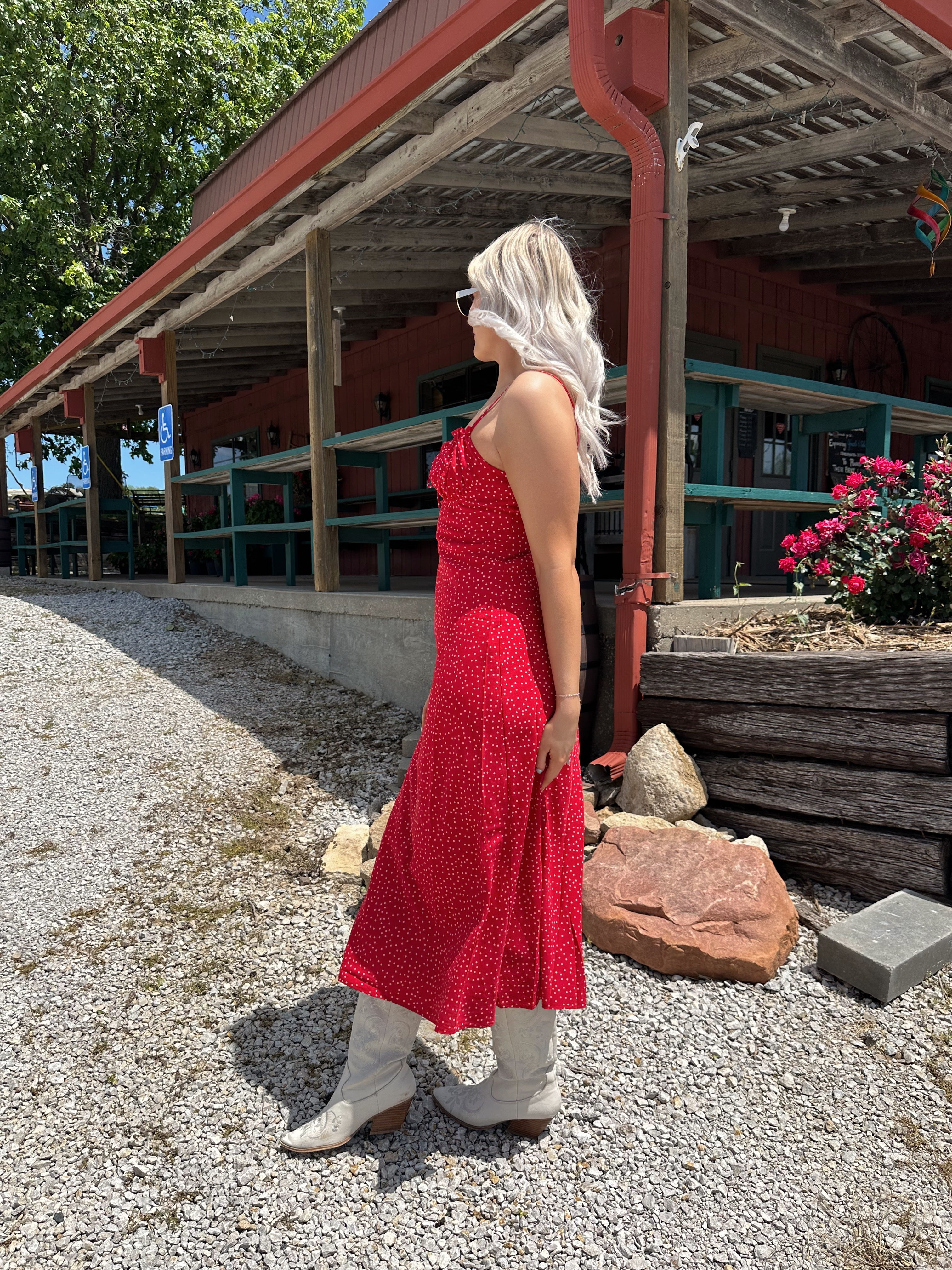 Red and white polka dot midi dress with adjustable spaghetti straps and tie neckline.