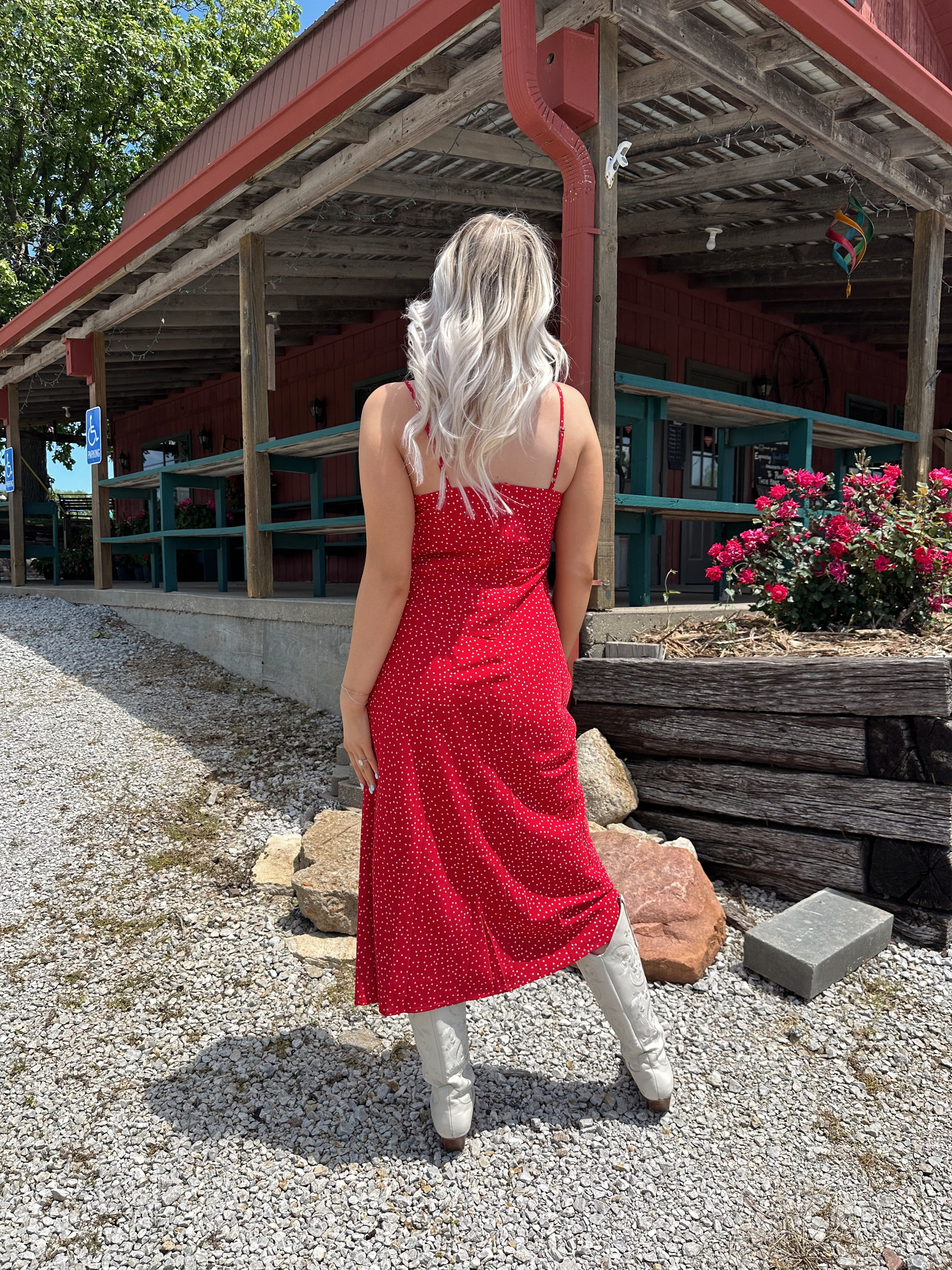 Red and white polka dot midi dress with adjustable spaghetti straps and tie neckline.