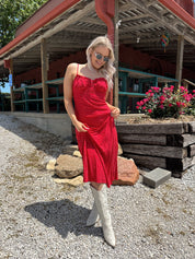 Red and white polka dot midi dress with adjustable spaghetti straps and tie neckline.