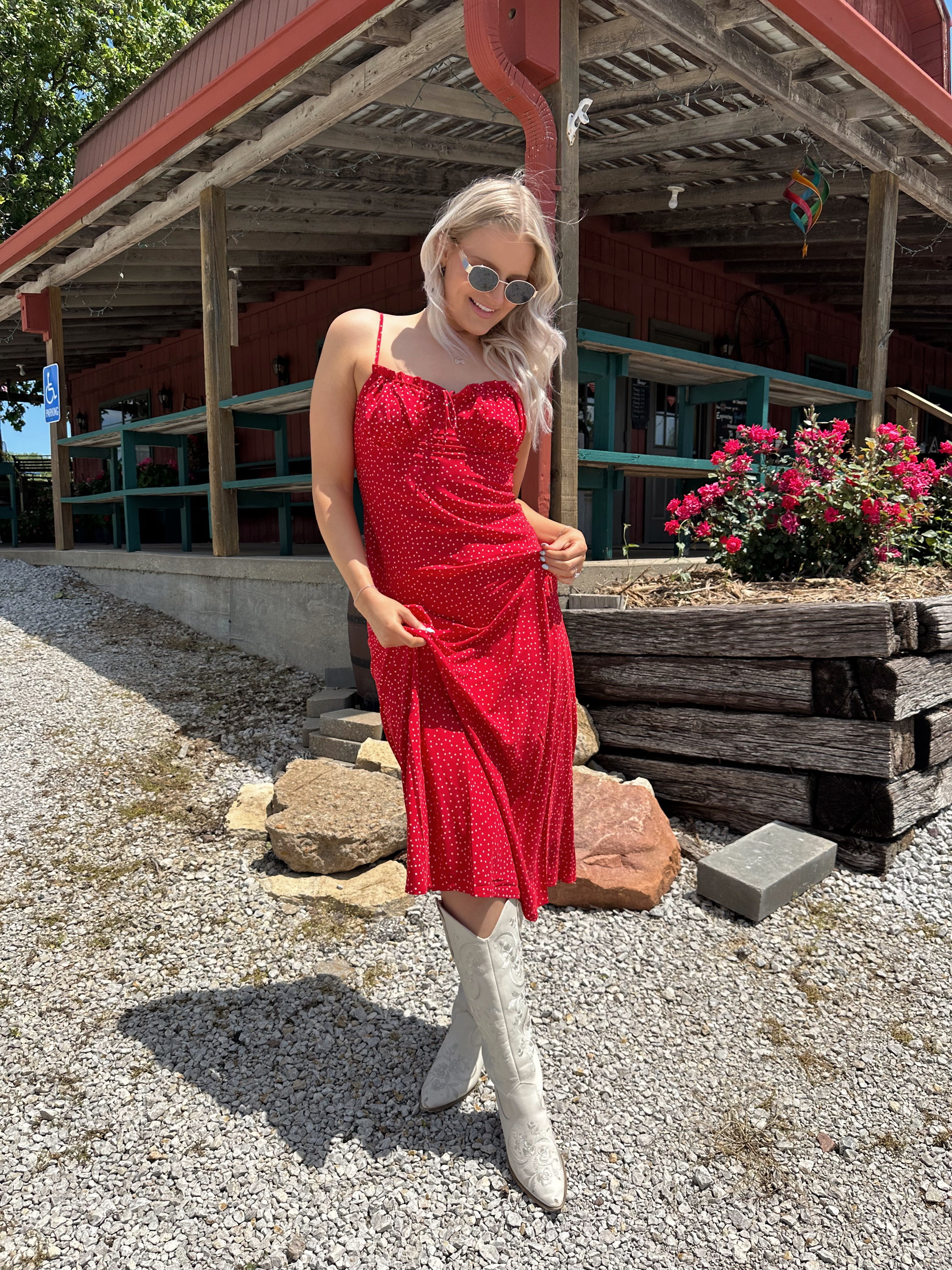 Red and white polka dot midi dress with adjustable spaghetti straps and tie neckline.