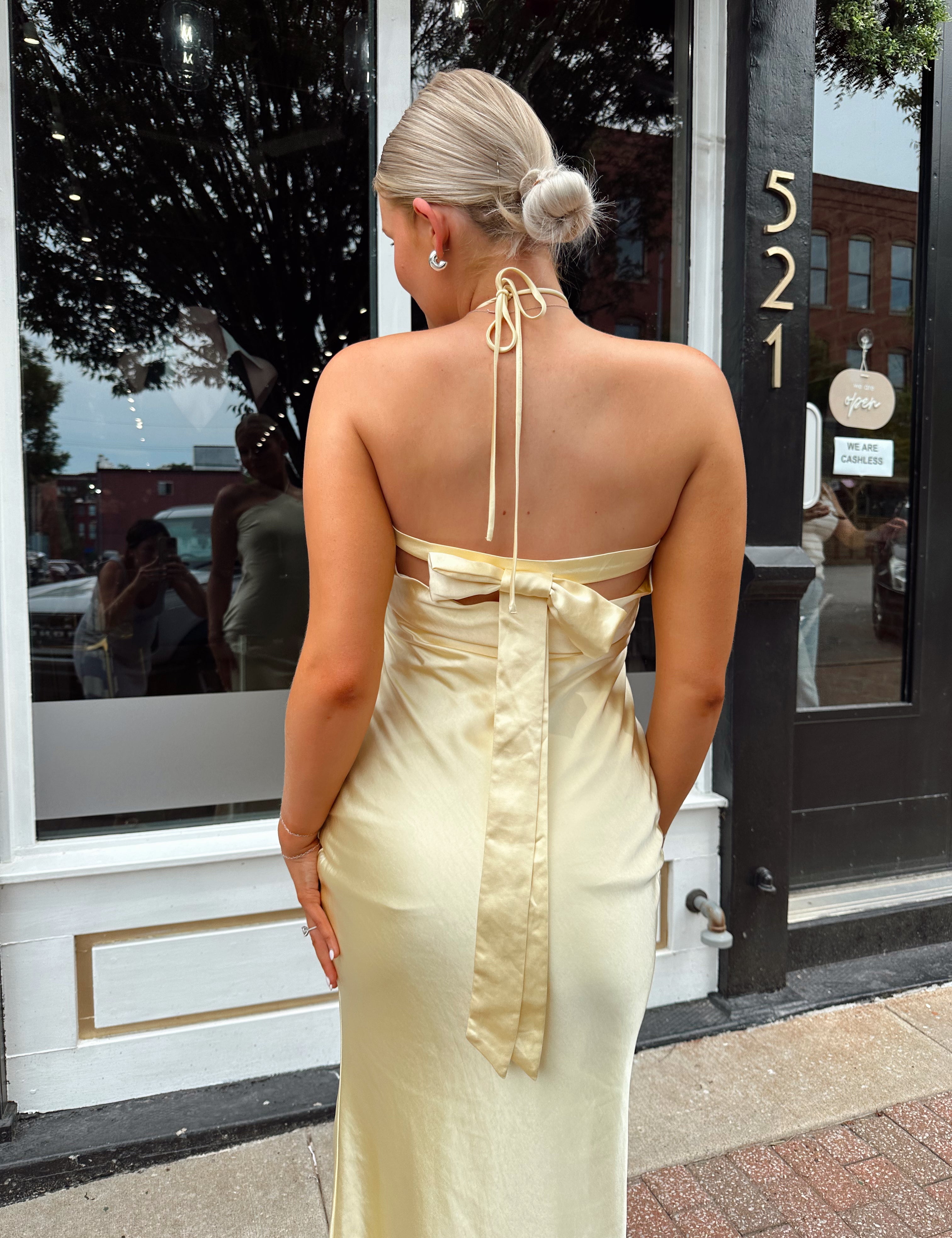 Yellow satin open back halter maxi dress with open back, bow detail.