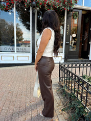 Woman wearing oatmeal knit sweater top with brown leather pant. 