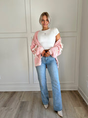 Pink knit cardigan with satin ribbon details and oversized cozy design.