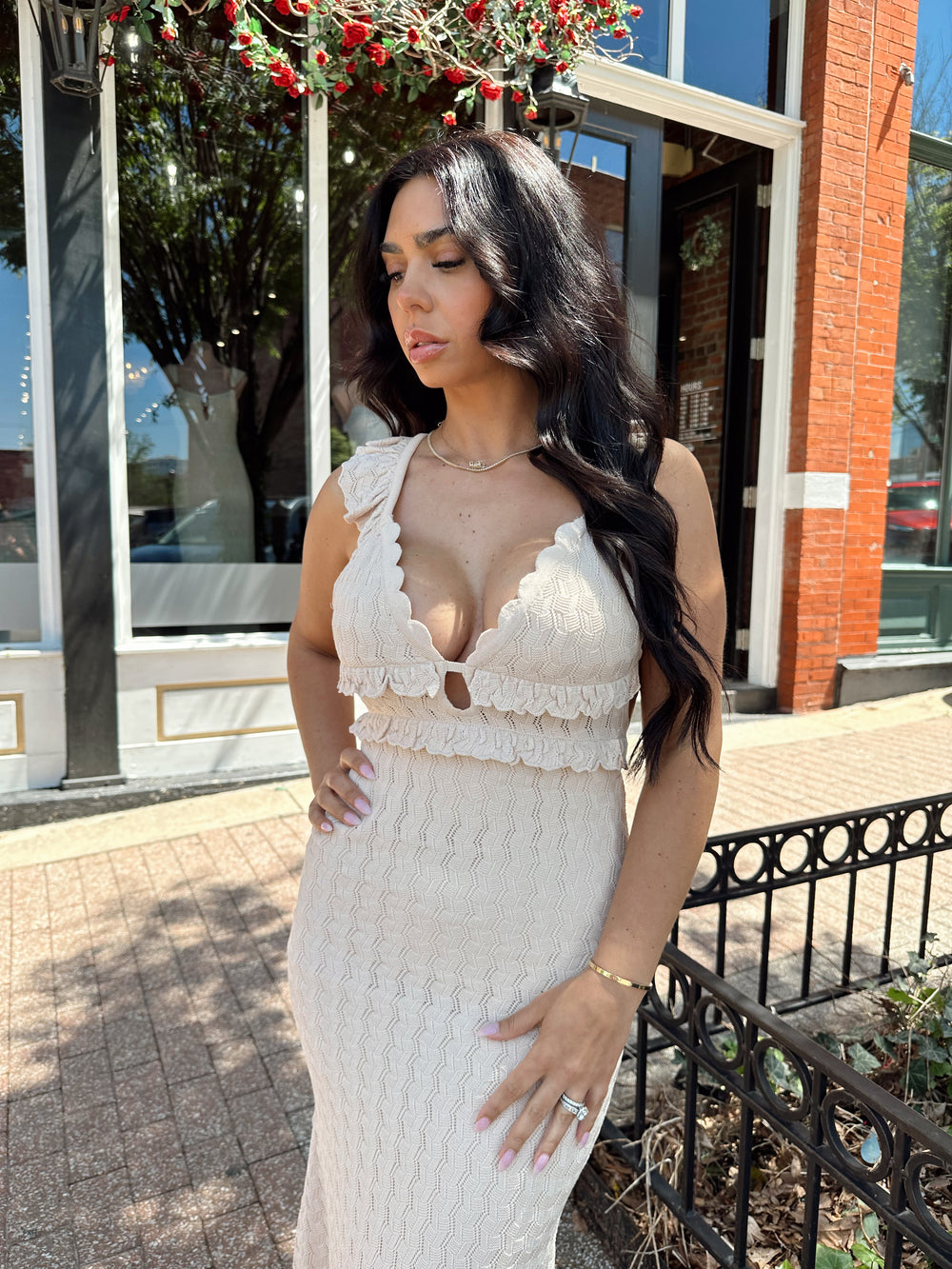 Woman wearing tan crochet midi dress with open back and self tie closure. 