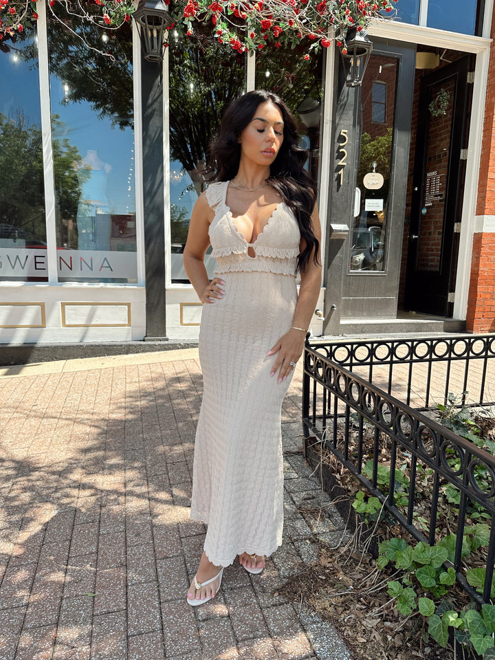 Woman wearing tan crochet midi dress with open back and self tie closure. 