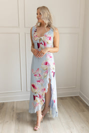 Blue maxi dress with pink floral pattern. Slit with a ruffle detail. 