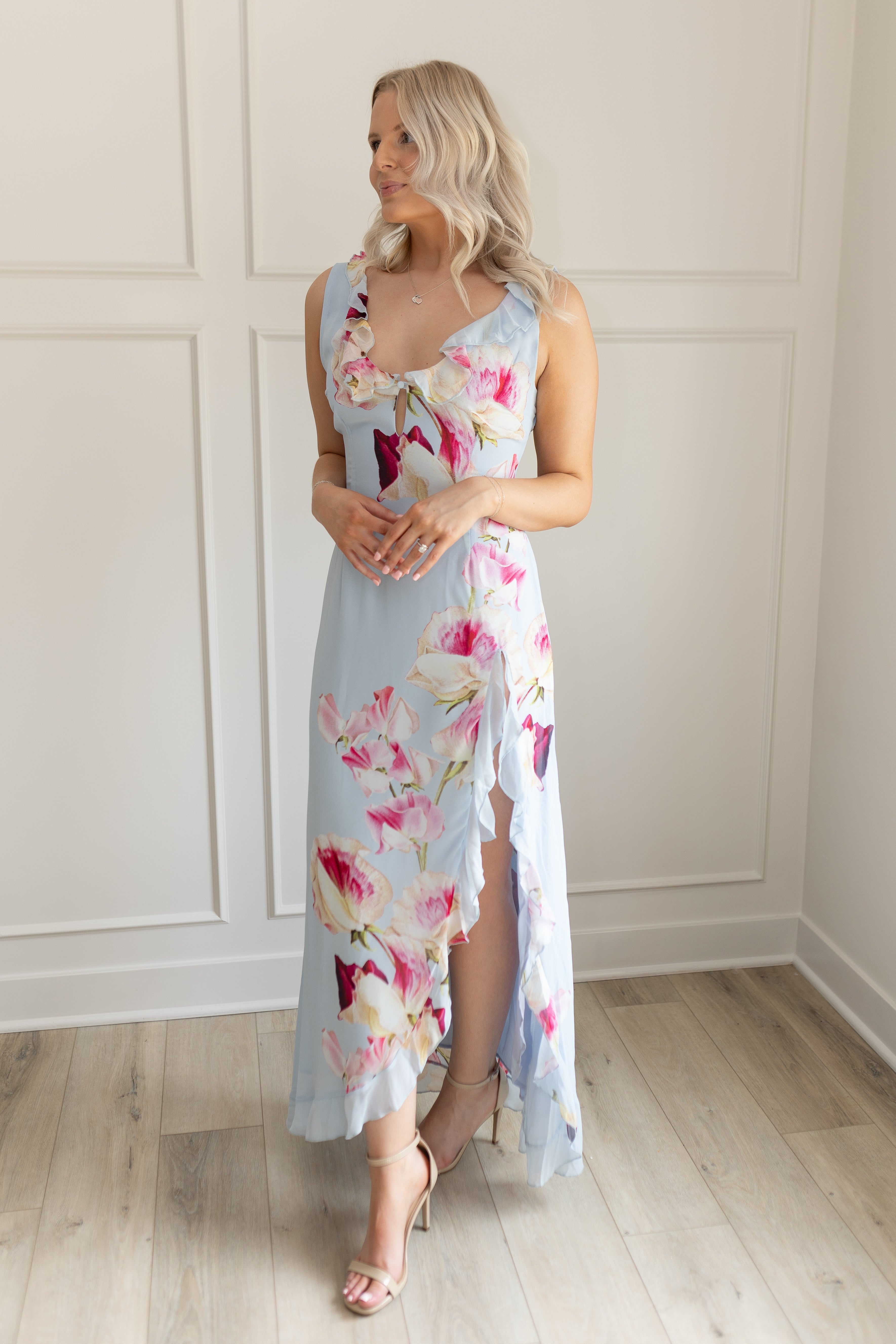 Blue maxi dress with pink floral pattern. Slit with a ruffle detail. 