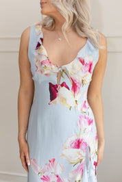 Blue maxi dress with pink floral pattern. Slit with a ruffle detail. 