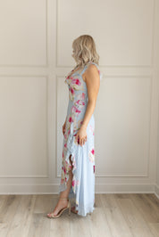 Blue maxi dress with pink floral pattern. Slit with a ruffle detail. 