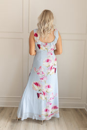 Blue maxi dress with pink floral pattern. Slit with a ruffle detail. 