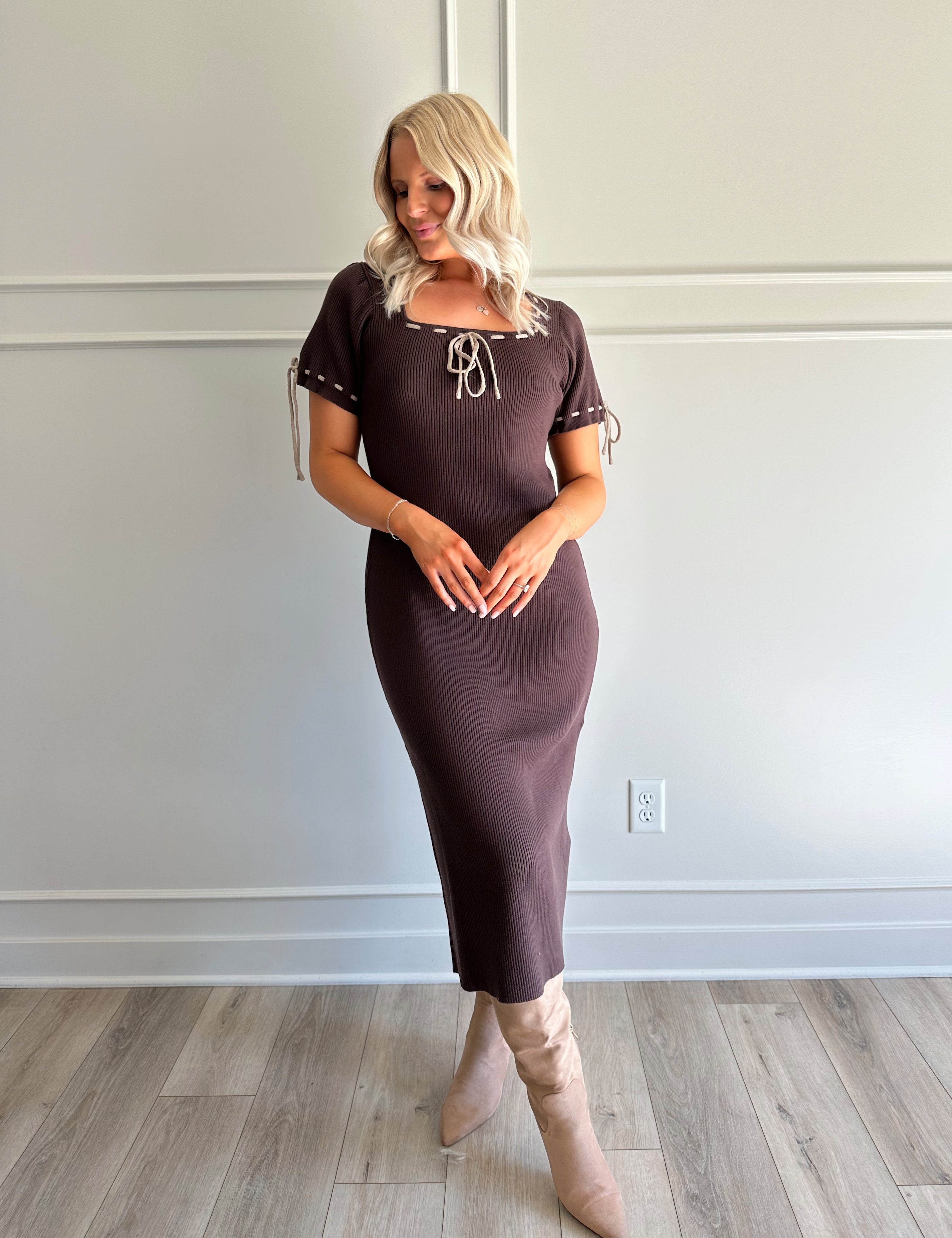 Woman wearing chocolate brown sweater midi dress with contrast trim and tie details.