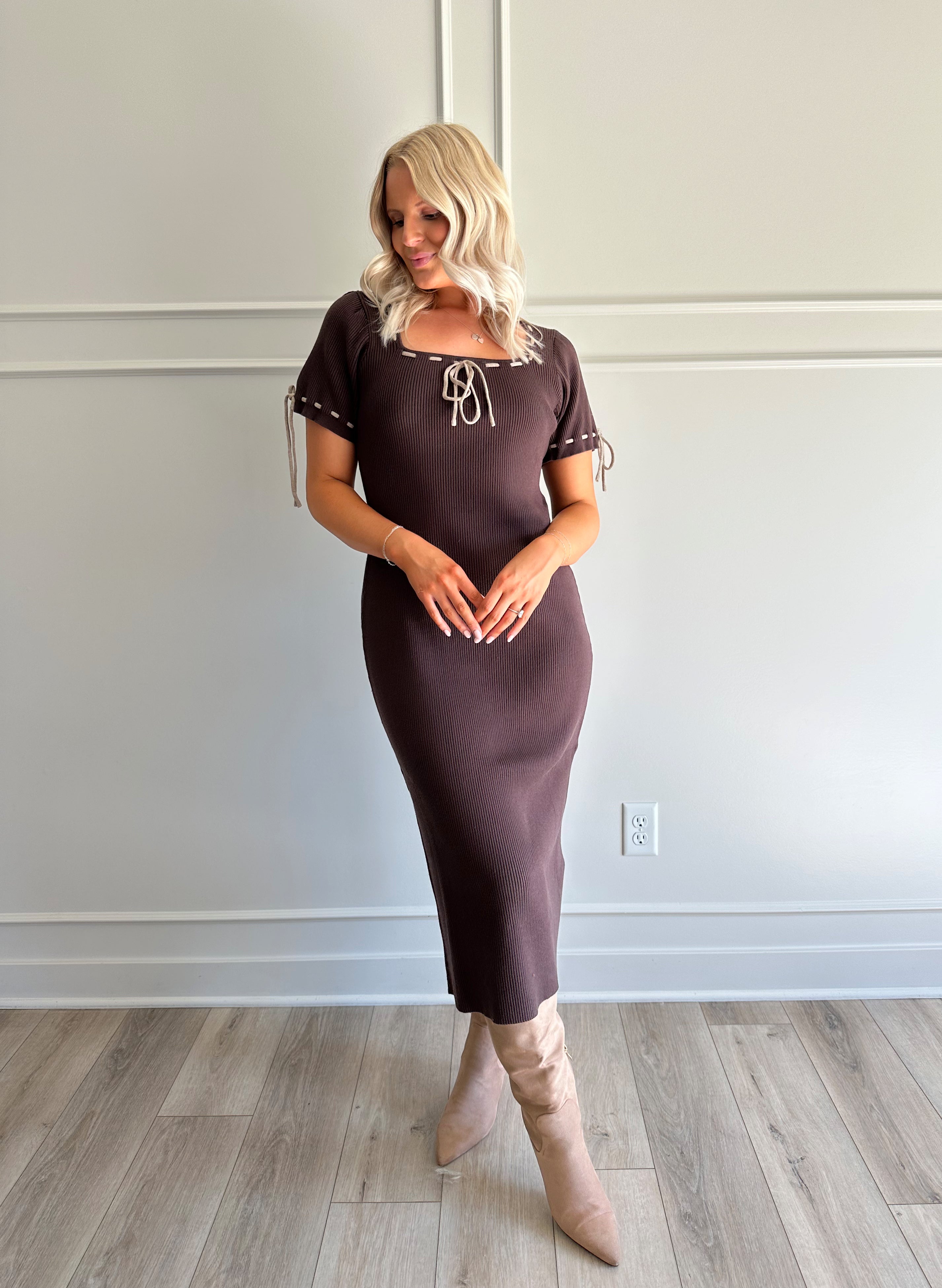 Woman wearing chocolate brown sweater midi dress with contrast trim and tie details.