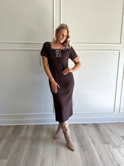Woman wearing chocolate brown sweater midi dress with contrast trim and tie details.