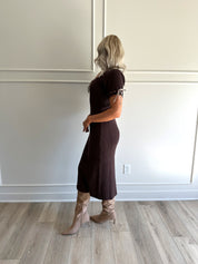 Woman wearing chocolate brown sweater midi dress with contrast trim and tie details.