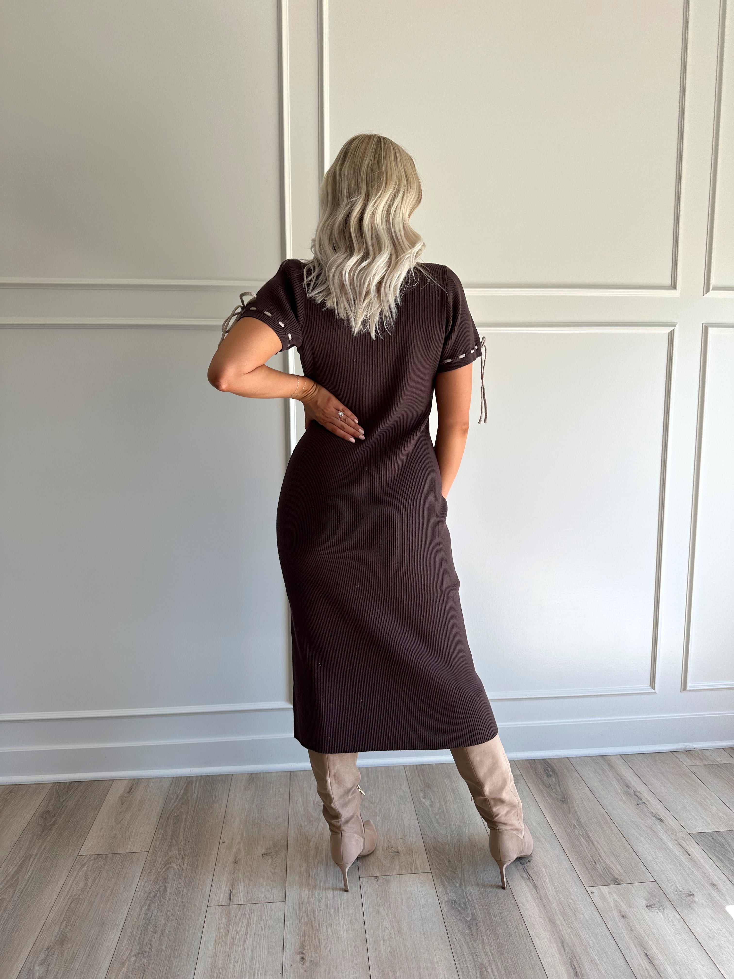Woman wearing chocolate brown sweater midi dress with contrast trim and tie details.