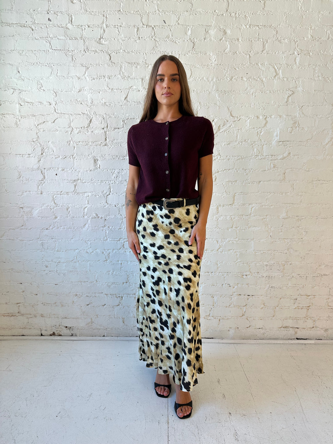 Woman wearing leopard satin belted maxi skirt with burgundy sweater top. 