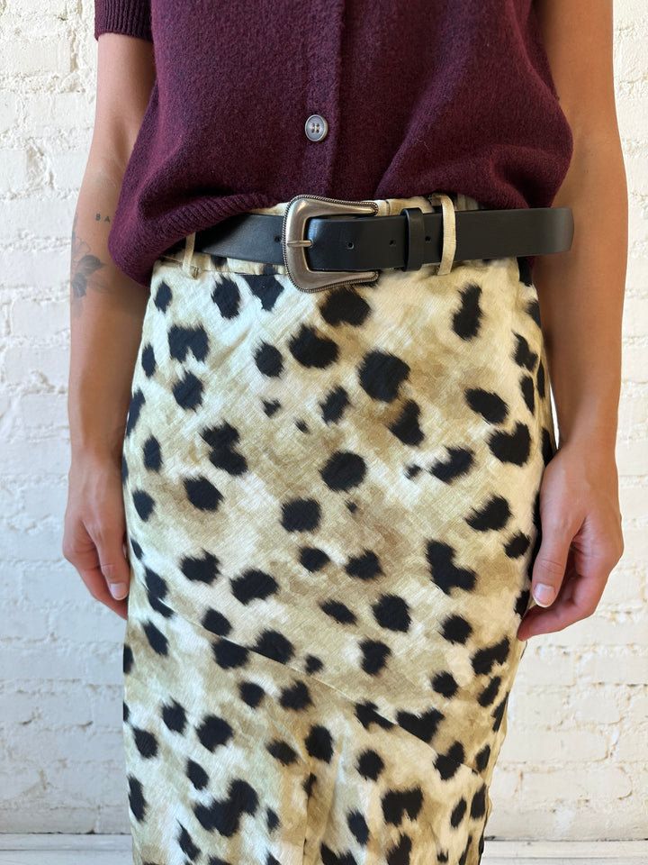 Woman wearing leopard satin belted maxi skirt with burgundy sweater top. 