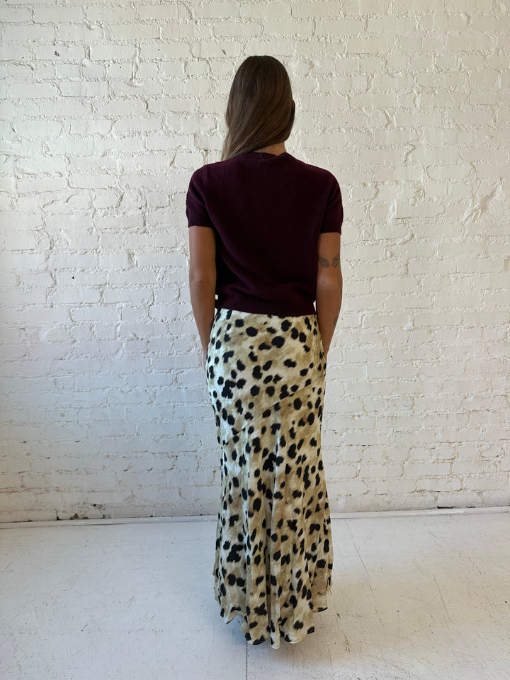 Woman wearing leopard satin belted maxi skirt with burgundy sweater top. 