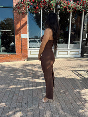 Woman wearing brown fitted square neck midi dress with slit in the back.