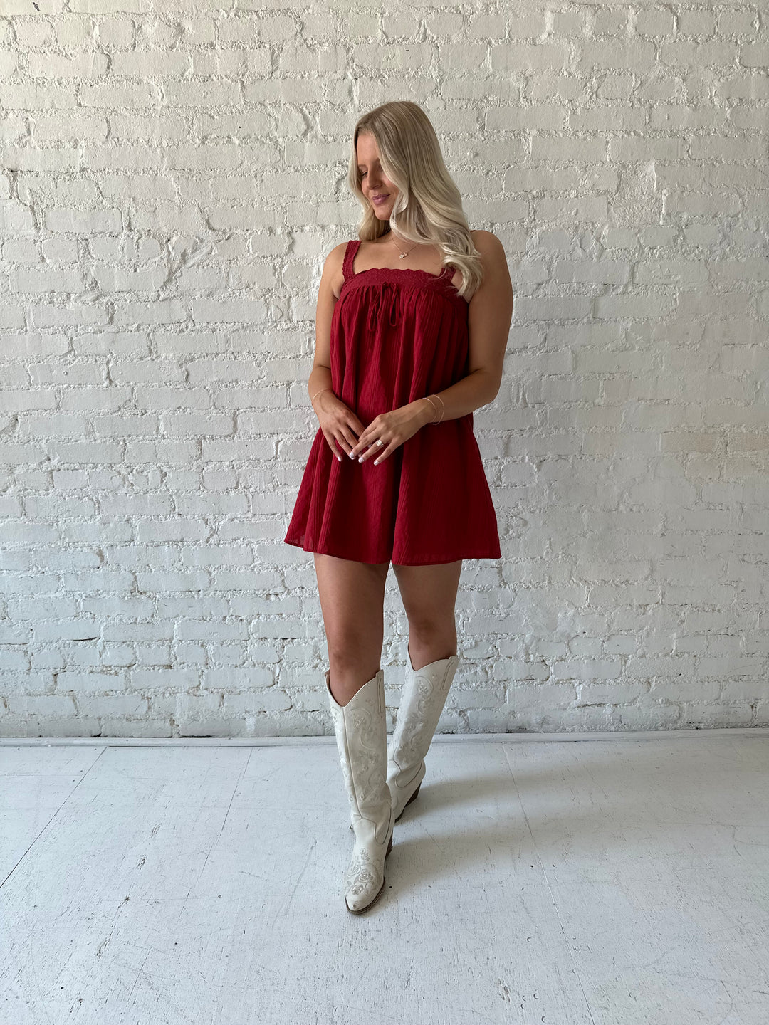 Woman wearing red shift mini dress with textured trim detail.