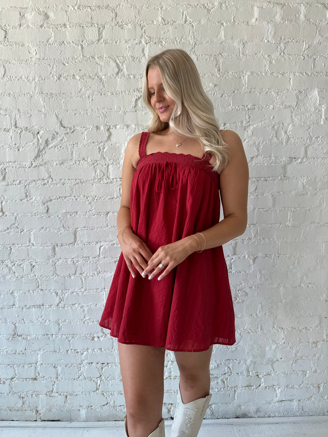 Woman wearing red shift mini dress with textured trim detail.
