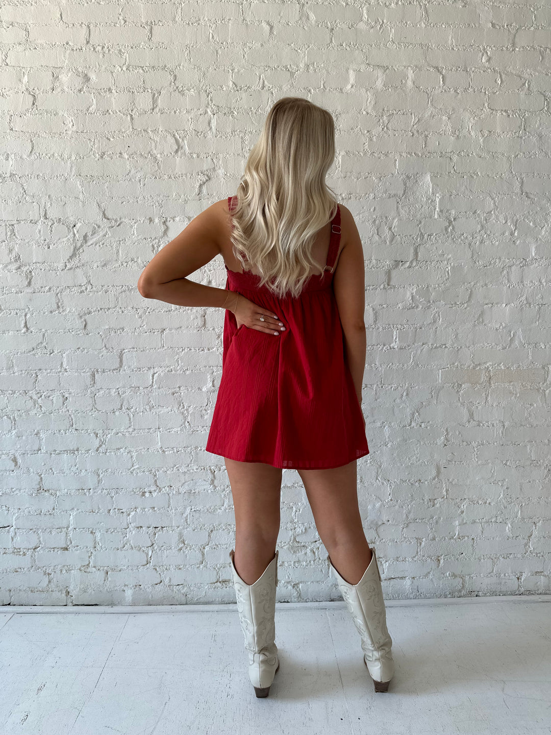 Woman wearing red shift mini dress with textured trim detail.
