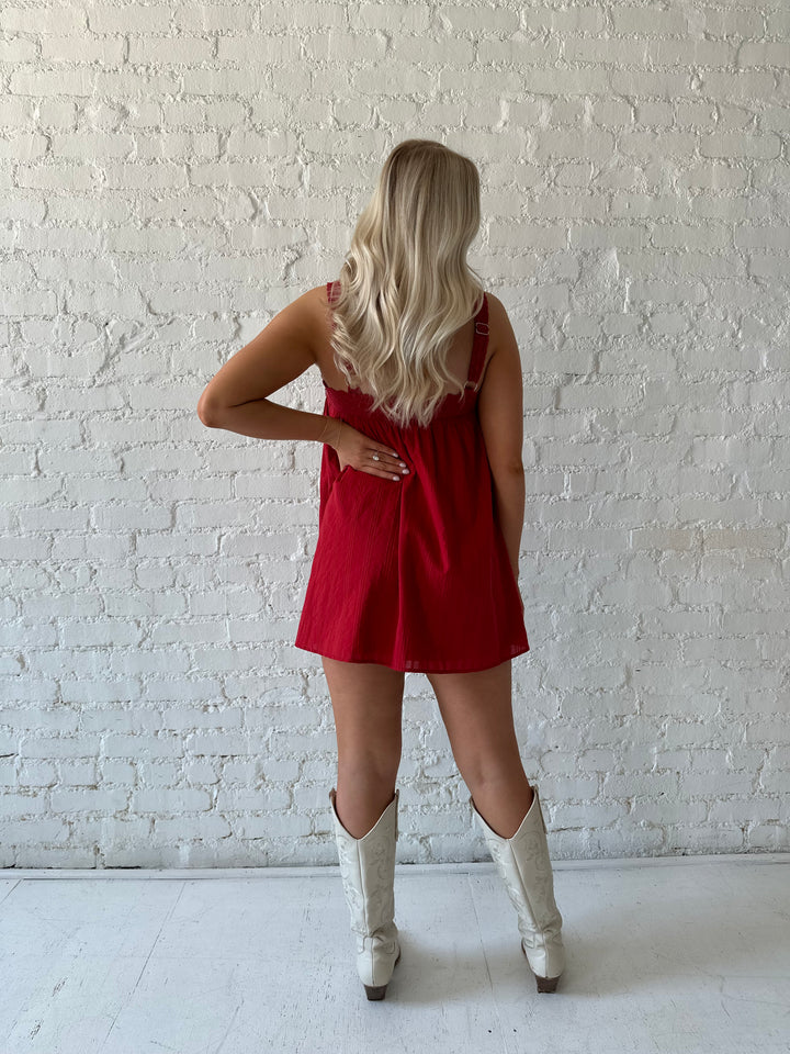 Woman wearing red shift mini dress with textured trim detail.