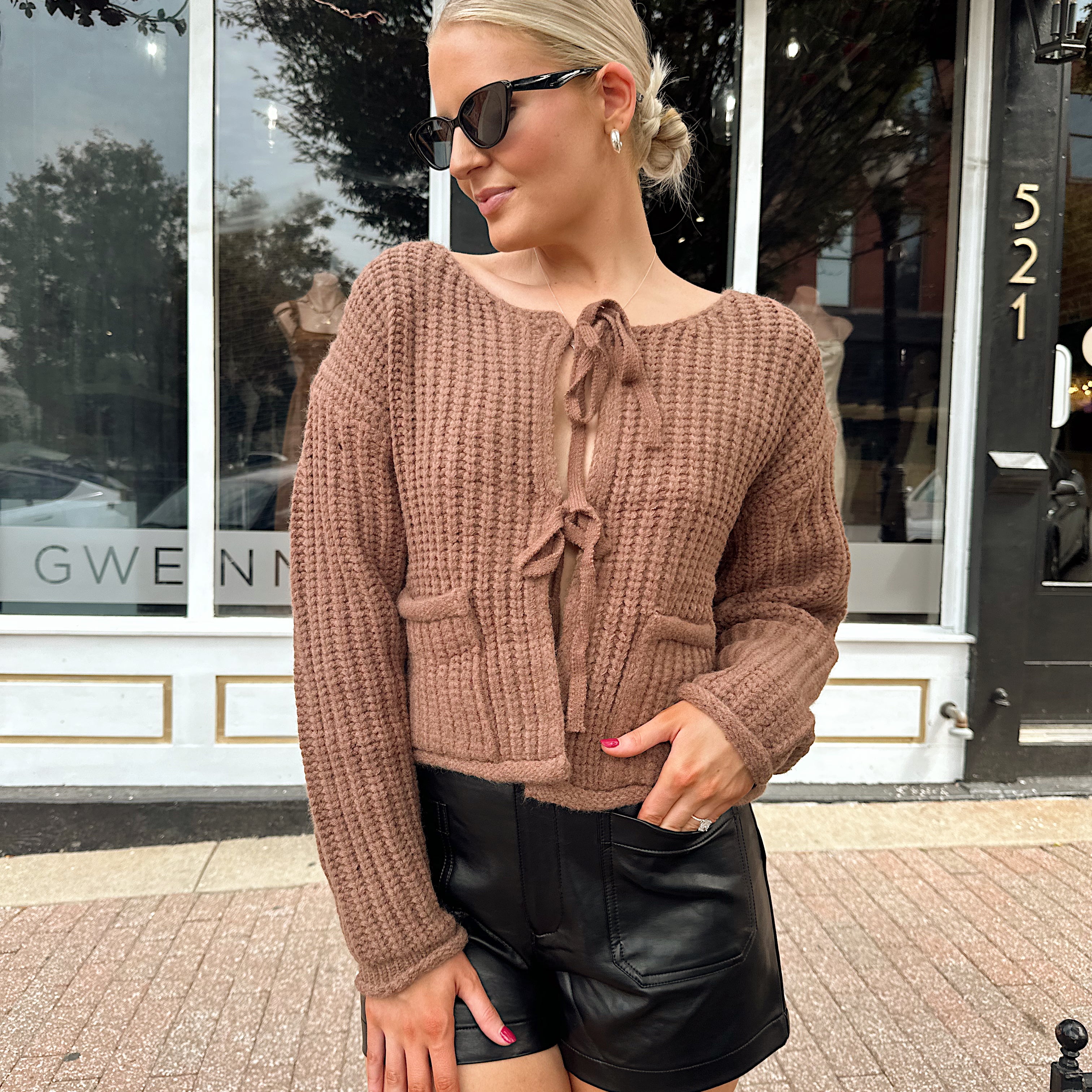 Woman wearing mocha brown knit front tie cardigan with functional front pockets.