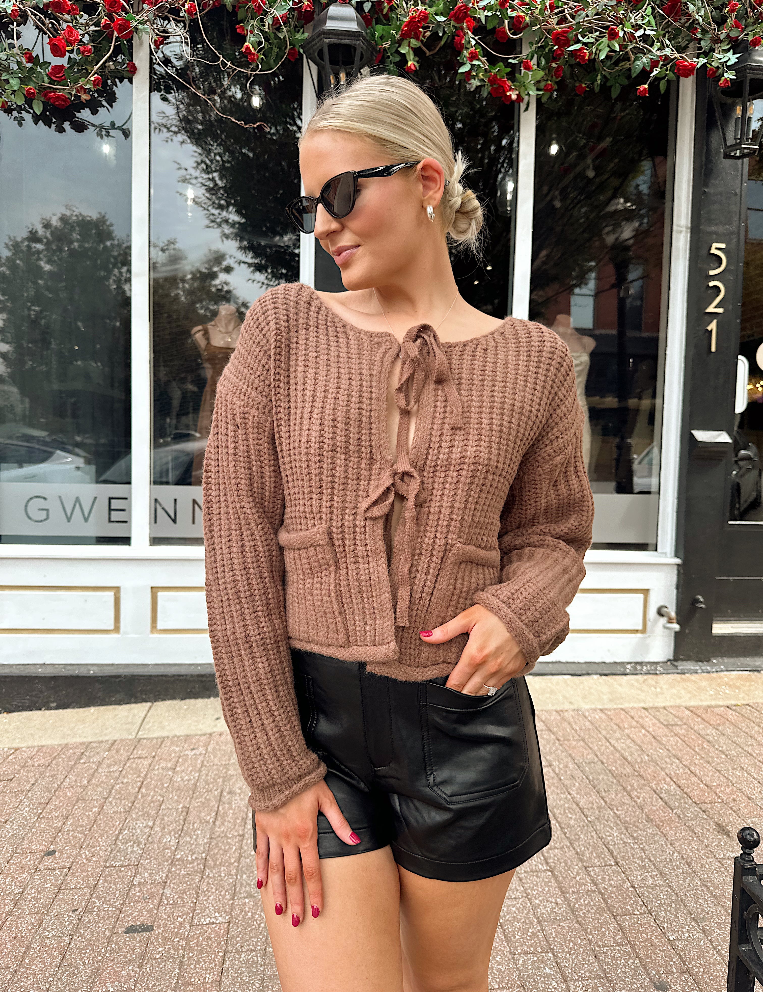 Woman wearing mocha brown knit front tie cardigan with functional front pockets.