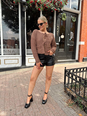 Woman wearing mocha brown knit front tie cardigan with functional front pockets.