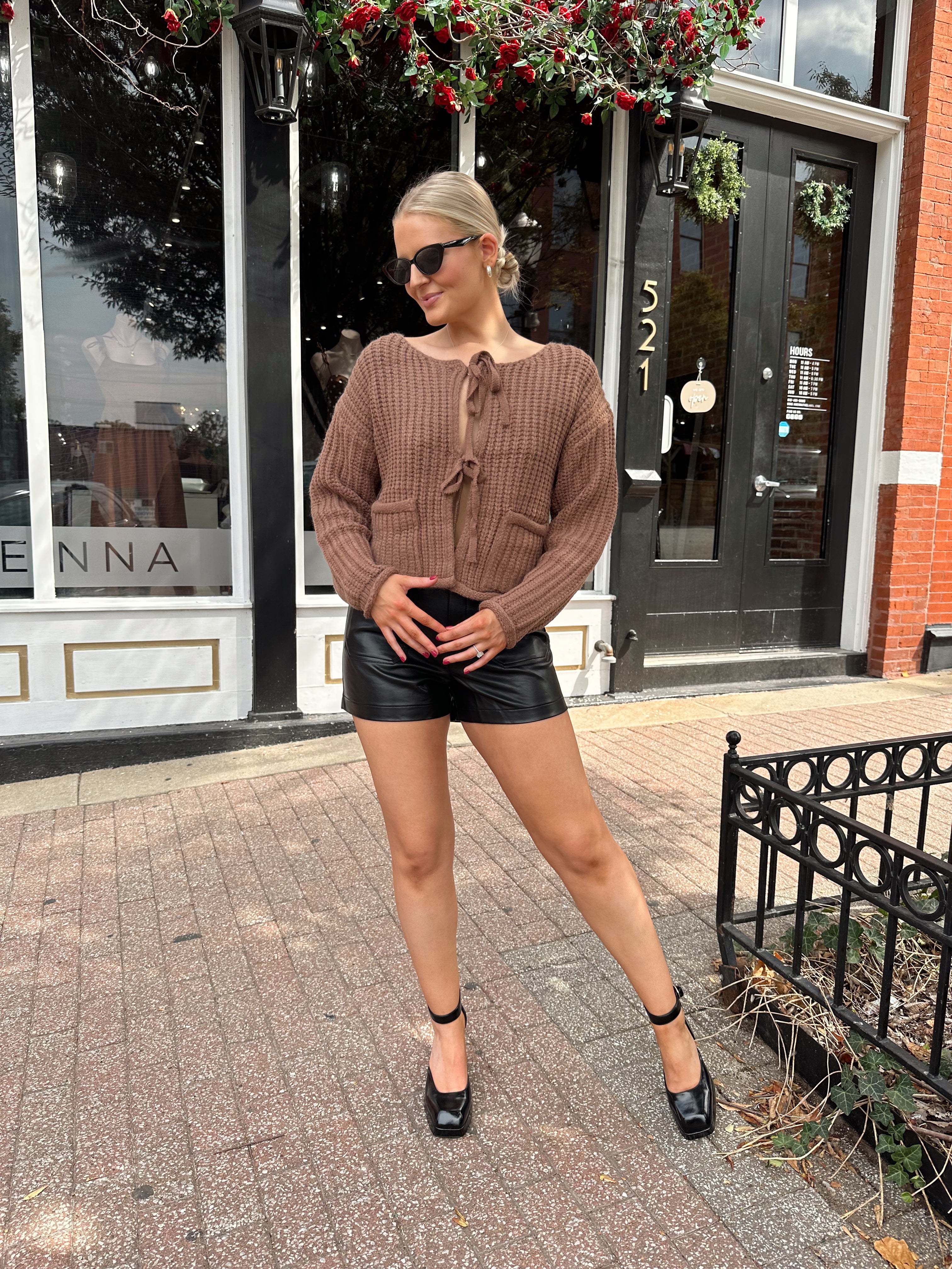 Woman wearing mocha brown knit front tie cardigan with functional front pockets.