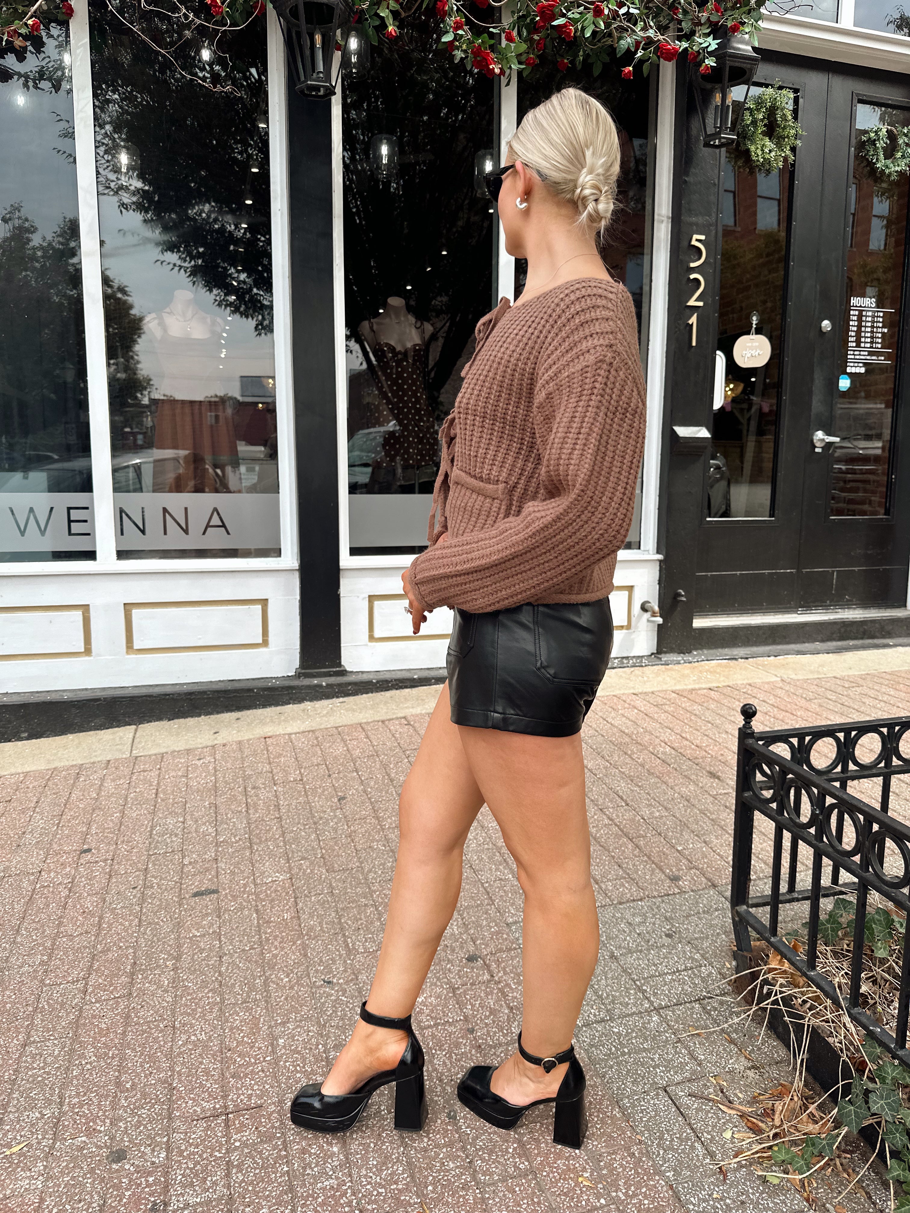Woman wearing mocha brown knit front tie cardigan with functional front pockets.