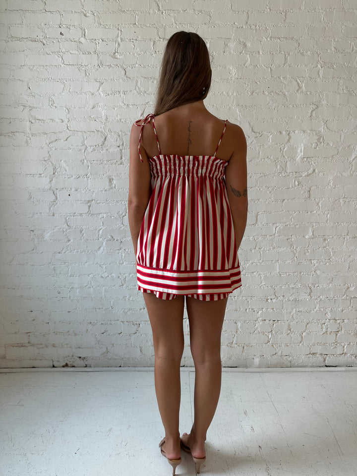 Woman wearing red striped two piece short set with smocked neckline detailing. 