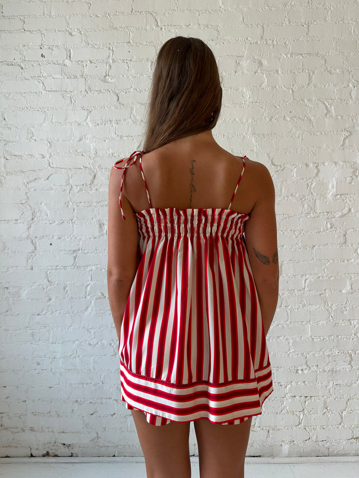 Woman wearing red striped two piece short set with smocked neckline detailing. 