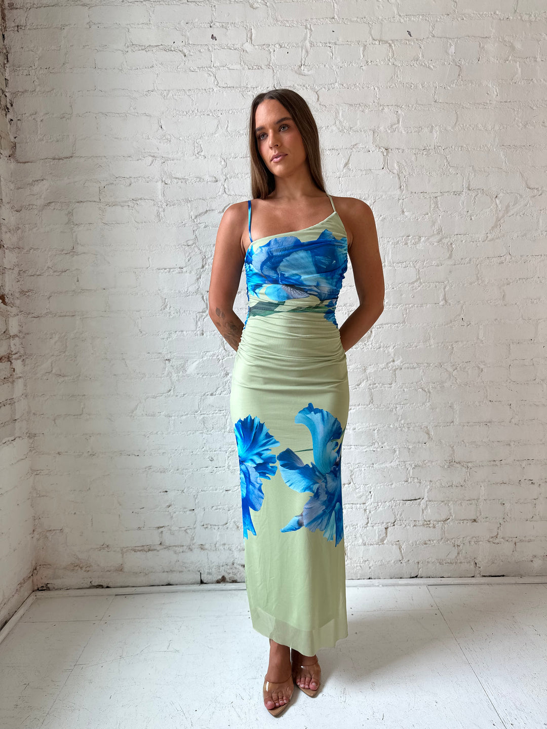 Woman wearing green mesh midi dress with blue floral pattern.