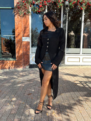 Woman wearing knit sweater duster cardigan with button closure. 