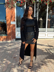 Woman wearing knit sweater duster cardigan with button closure. 