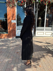 Woman wearing knit sweater duster cardigan with button closure. 