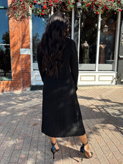 Woman wearing knit sweater duster cardigan with button closure. 