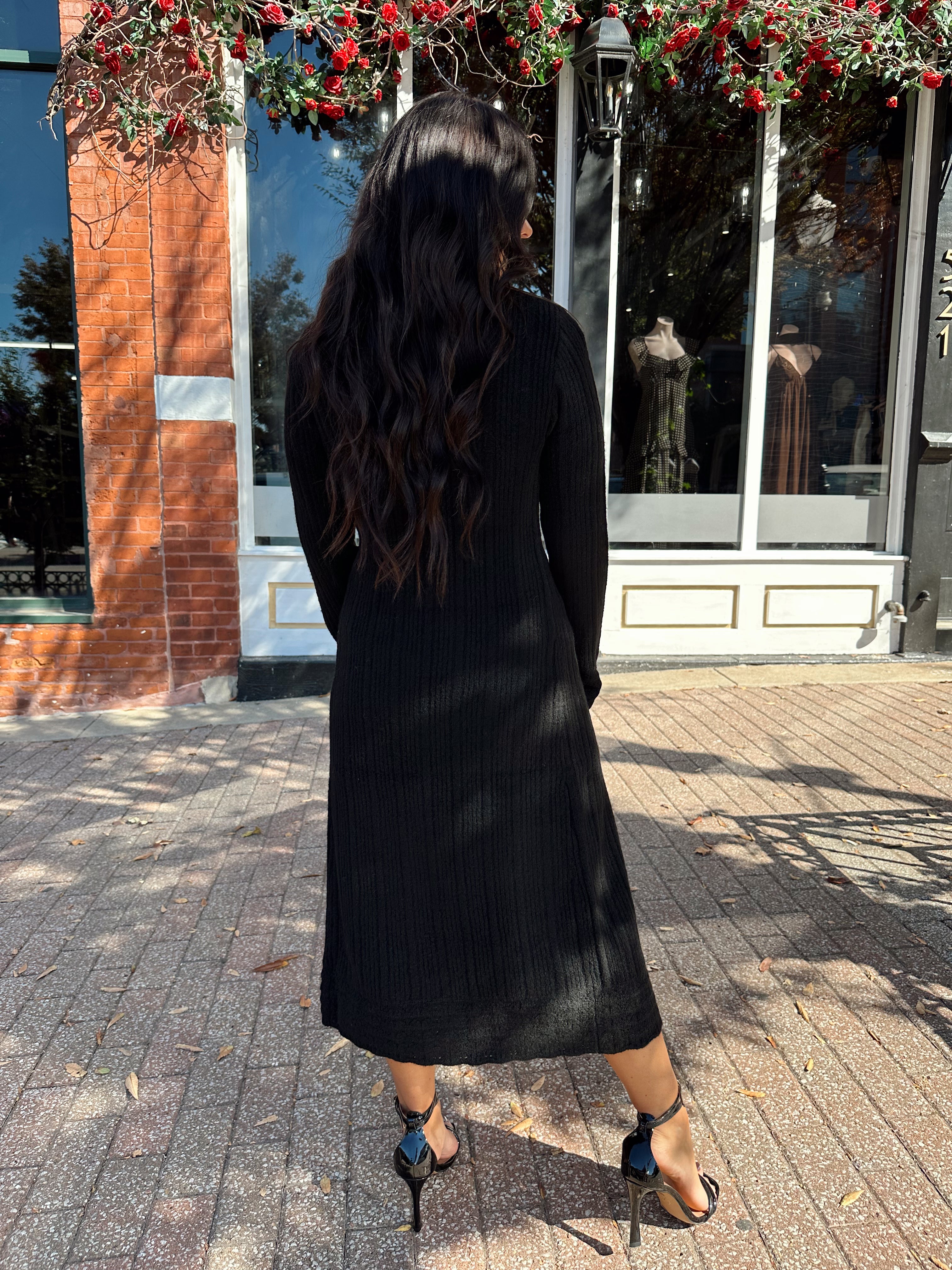 Woman wearing knit sweater duster cardigan with button closure. 