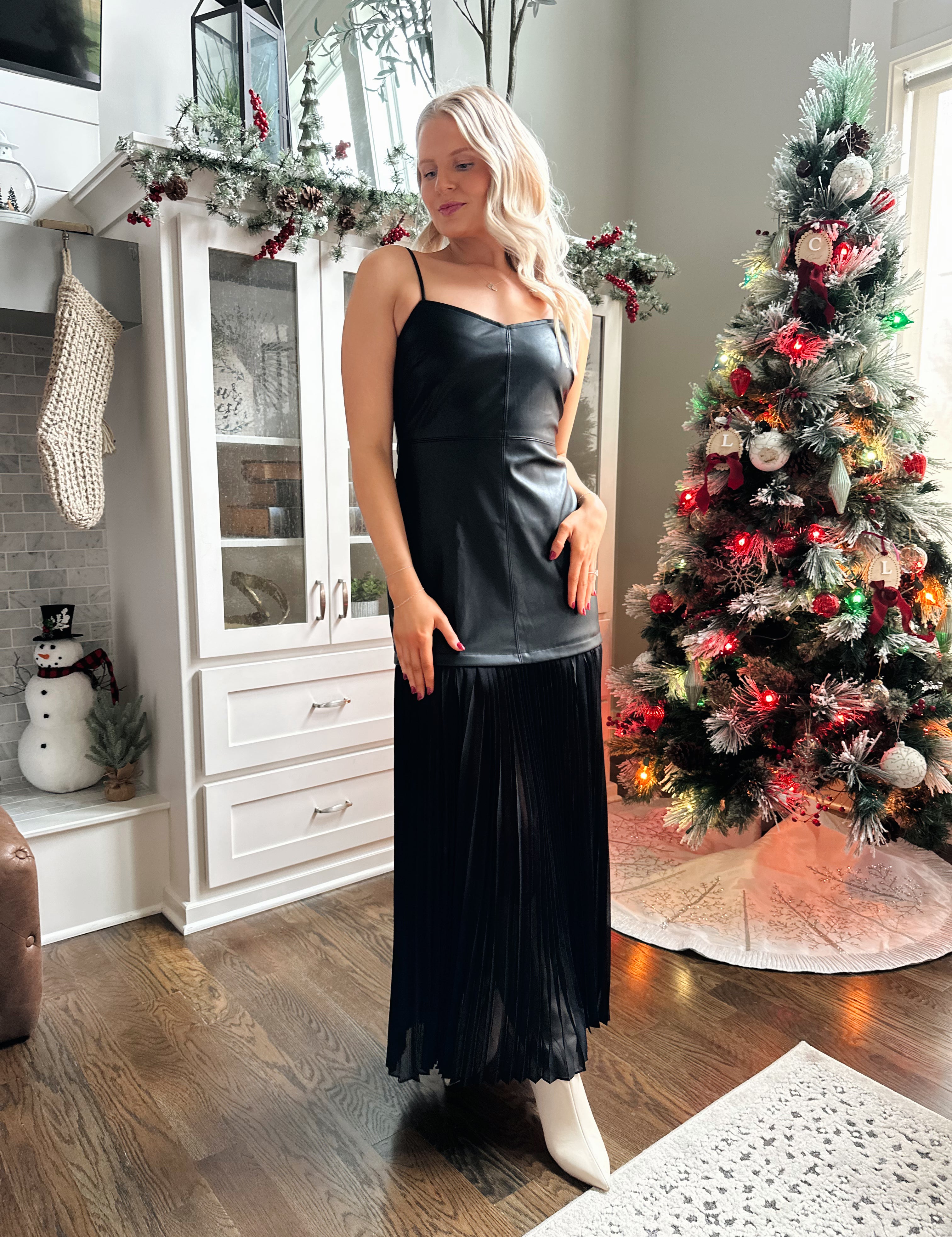 Woman wearing black leather contrast maxi dress with plisse bottom. 