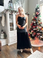 Woman wearing black leather contrast maxi dress with plisse bottom. 