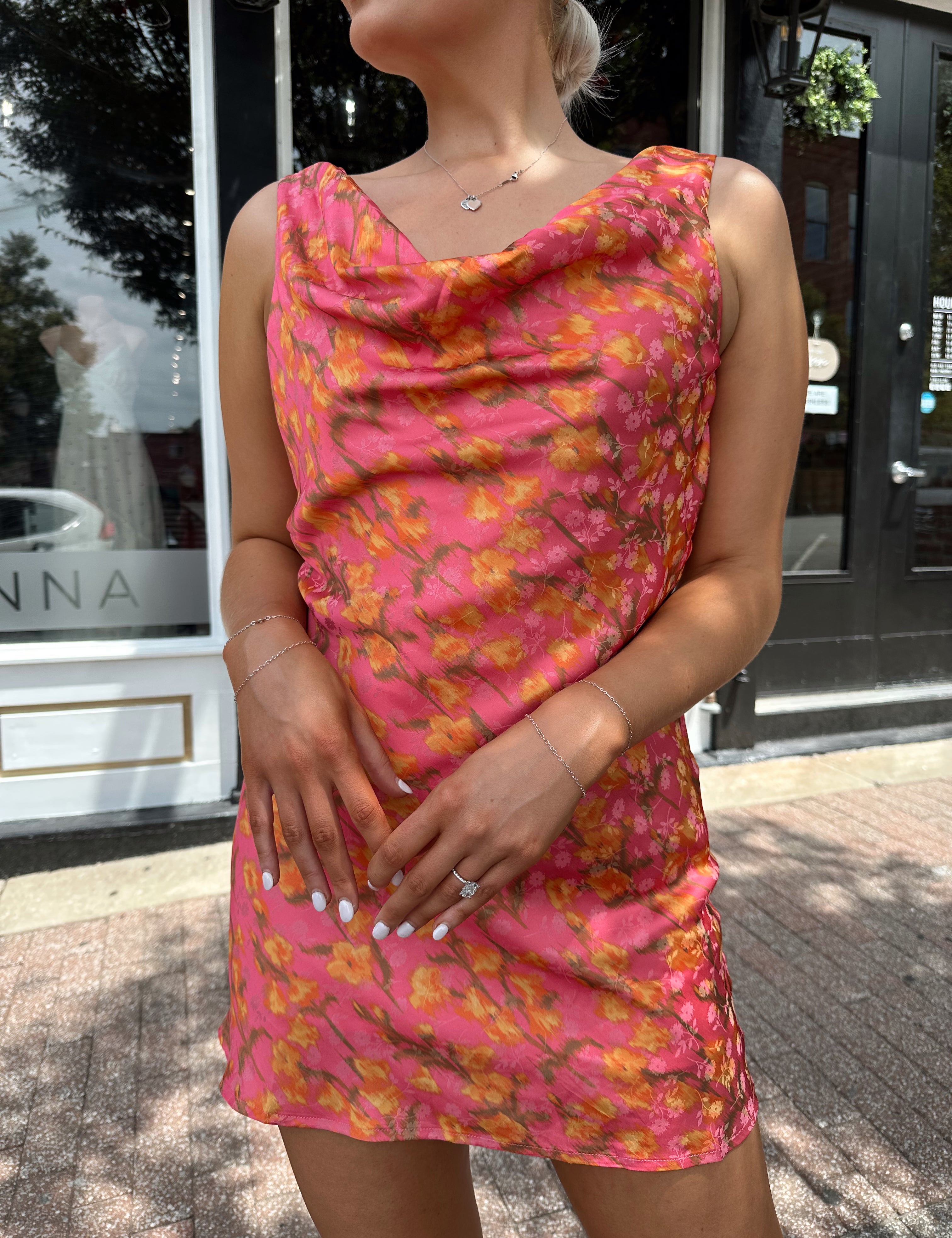 Hot pink satin mini dress with cowl neckline and rust colored floral pattern.
